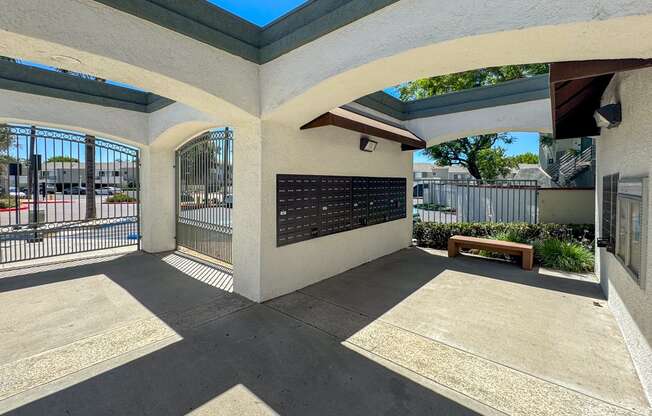A sunny day at the courtyard with a bench and a wall with a plaque.