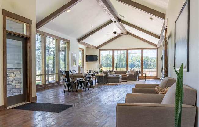 A living room with a stone wall and a ceiling fan at Riverplace Apartment Homes, Independence, 97351