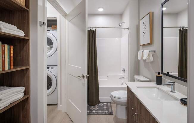 A bathroom with a white sink, toilet, and bathtub with a brown shower curtain.