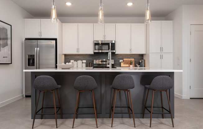 a kitchen with a large island with three stools