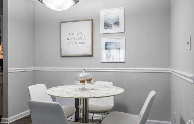 a dining room with a marble table and white chairs