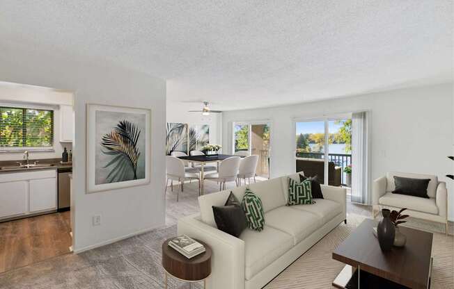 A living room with a white couch and a painting on the wall.
