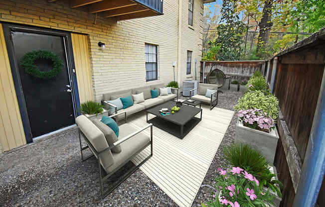 a patio with couches and a coffee table in a backyard