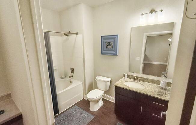 A bathroom with a toilet, sink, and shower.