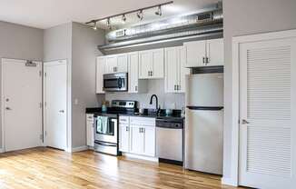 A kitchen with white cabinets and stainless steel appliances.