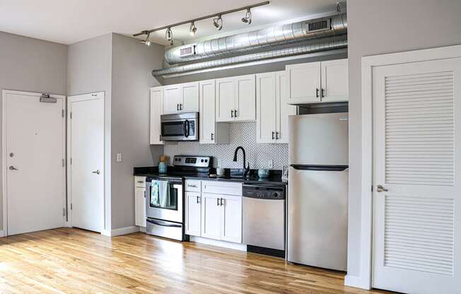 A kitchen with white cabinets and stainless steel appliances.