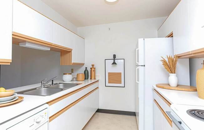 A kitchen with white cabinets and a white fridge.