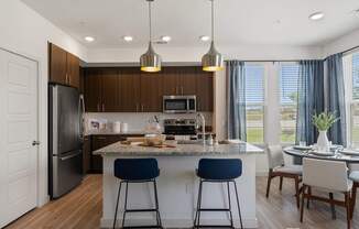 A modern kitchen with dark wood cabinets and a large island.