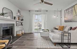A living room with a fireplace, a couch, and a rug.