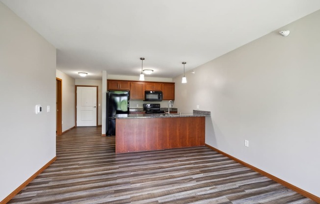 a spacious living room with a kitchen with a wood floor