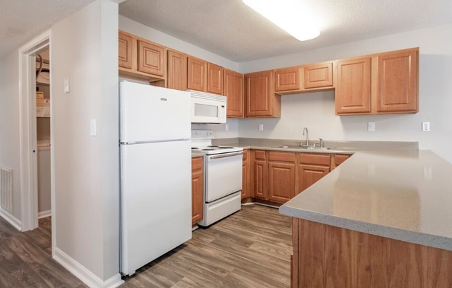 a kitchen with white appliances and wooden cabinets