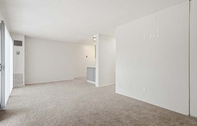 Empty room with carpeted floor and white walls.