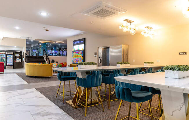 a long communal table with blue chairs in a lobby