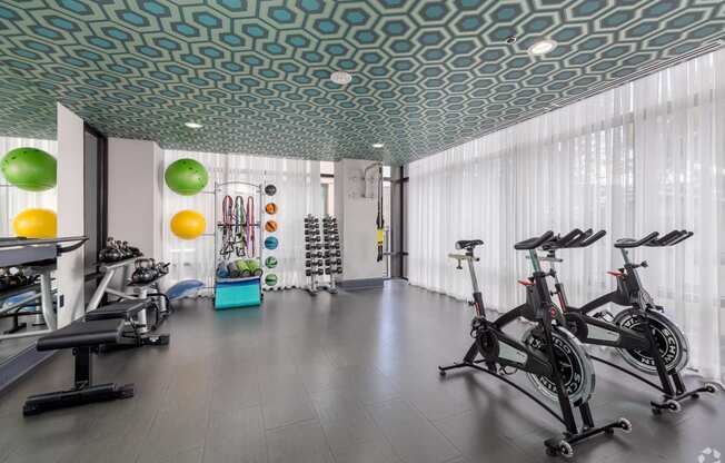 a gym with exercise bikes and a lot of windows