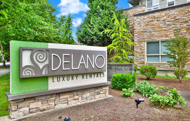 A sign for Delano Luxury Rentals in front of a building.