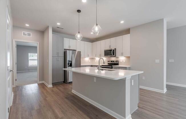 a kitchen with an island and a refrigerator and a sink