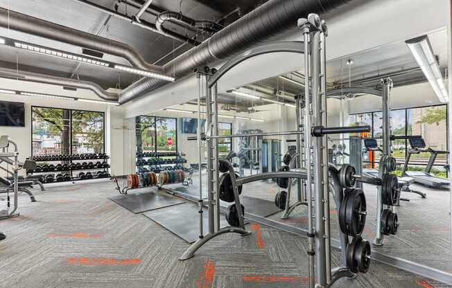 A gym with a variety of equipment including dumbbells and weight plates.