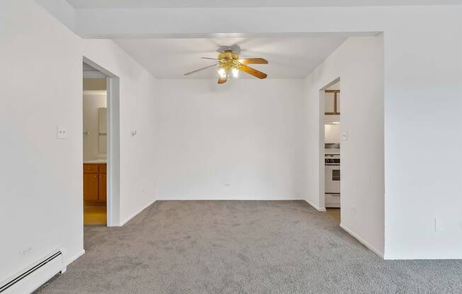 a bedroom with white walls and a ceiling fan