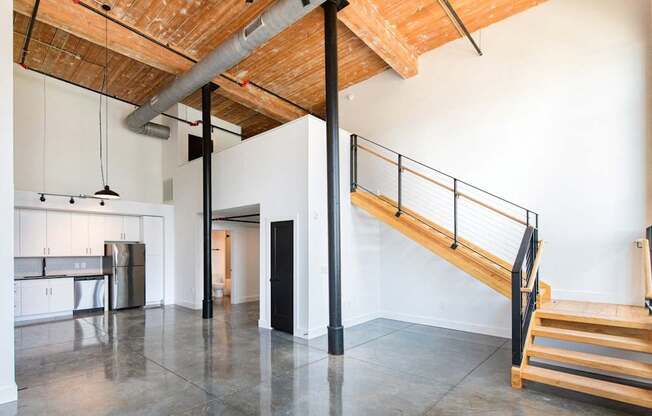 A room with a wooden ceiling and a staircase.