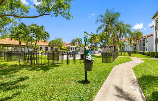 A sunny day at a park with a pathway and a mailbox.