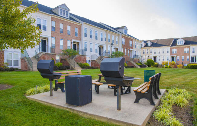 a park with a picnic table and benches in front of a building