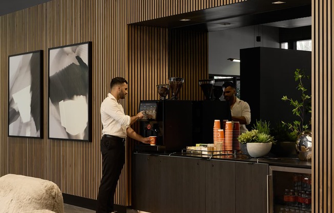 A person is standing at a counter with a plant on it.