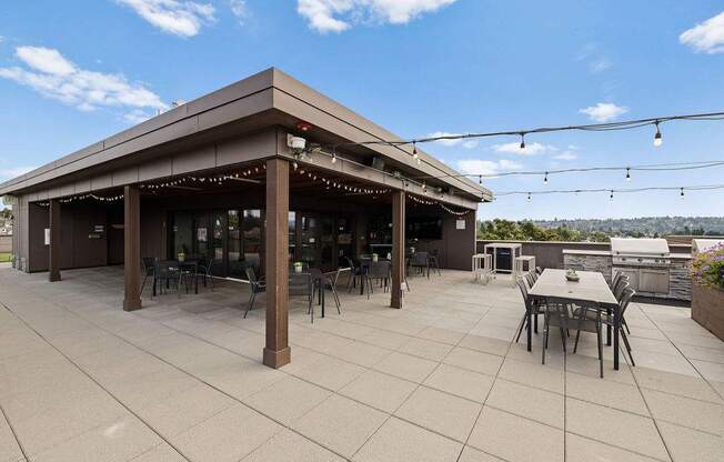 A patio with a table and chairs under a roof.