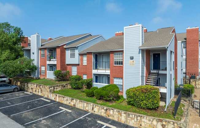 A parking lot in front of a red brick apartment building.