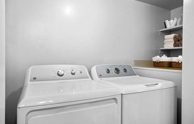 A white washing machine and dryer in a laundry room.