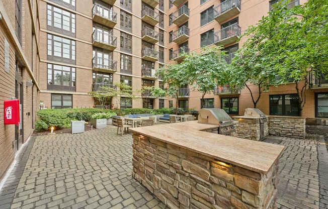 A courtyard with a stone barrier and a tree.