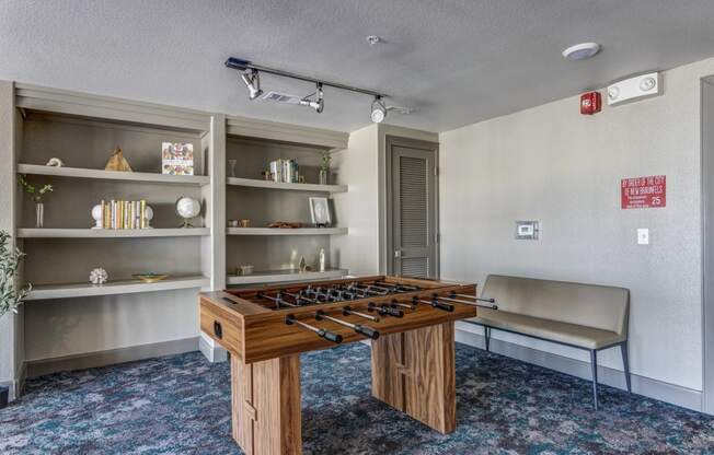 a room with a foosball table and a bench