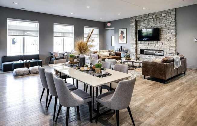 A modern dining room with a stone fireplace and a large table set for six.