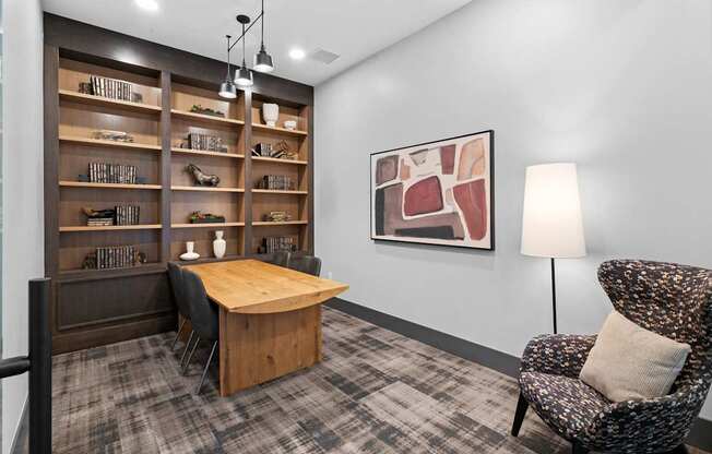 A room with a chair, a table, and a bookshelf.