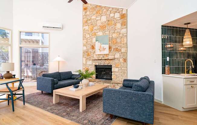 A living room with a stone wall and a fireplace.