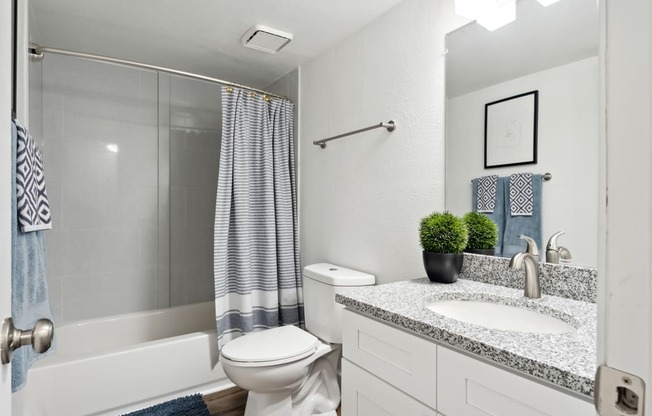 a bathroom with a white toilet next to a white bathtub at Linkhorn Bay Apartments, Virginia, 23451