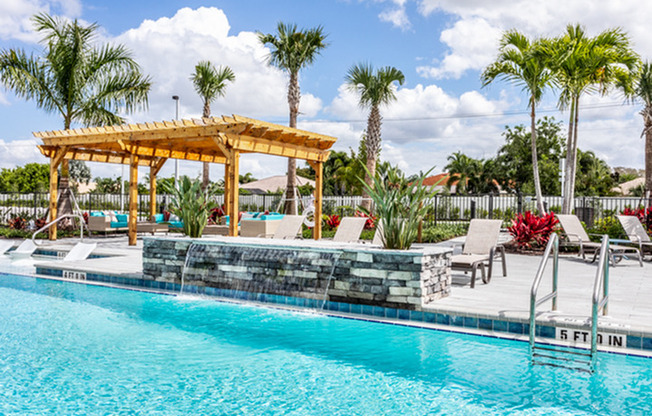 exterior pool with fountain and patio furniture in daytime