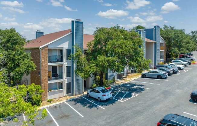 A parking lot with cars and a building in the background.
