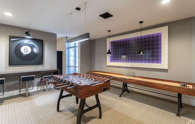 A room with a pool table and a purple wall hanging.