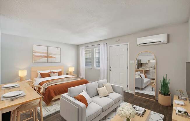 A well-lit bedroom with a bed, couch, and a dining table.