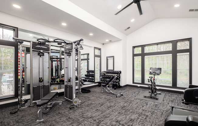 a home gym with weights and cardio equipment and large windows
