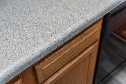 a kitchen counter with a granite counter top and wooden cabinets