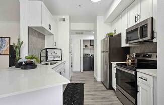 a kitchen with white cabinets and stainless steel appliances