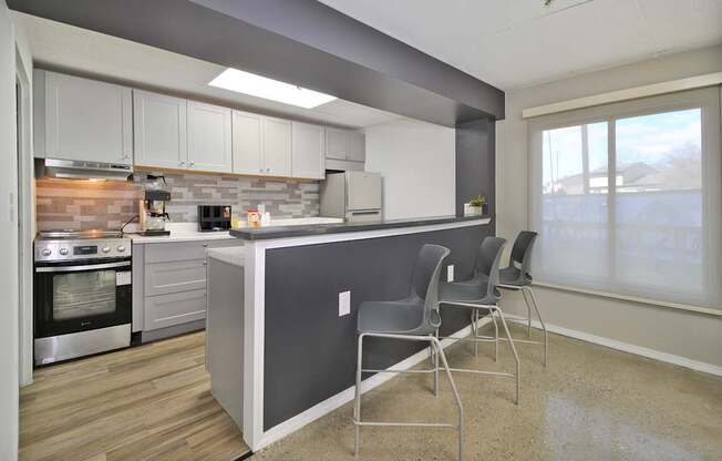 A kitchen with a grey island and white cabinets.