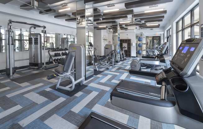 a gym with treadmills and other exercise equipment in a building with windows at The Hendrix, Atlanta