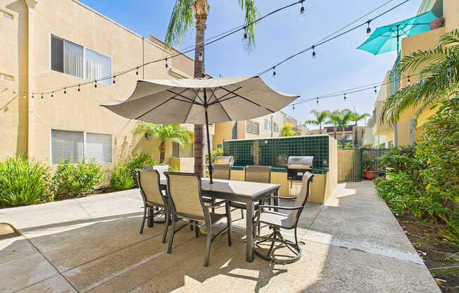 A patio with a table and chairs under an umbrella.