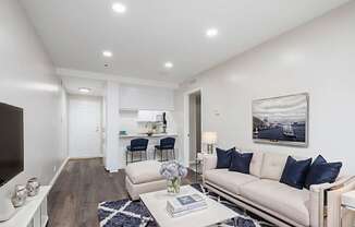 A modern living room with a white sofa and a coffee table.