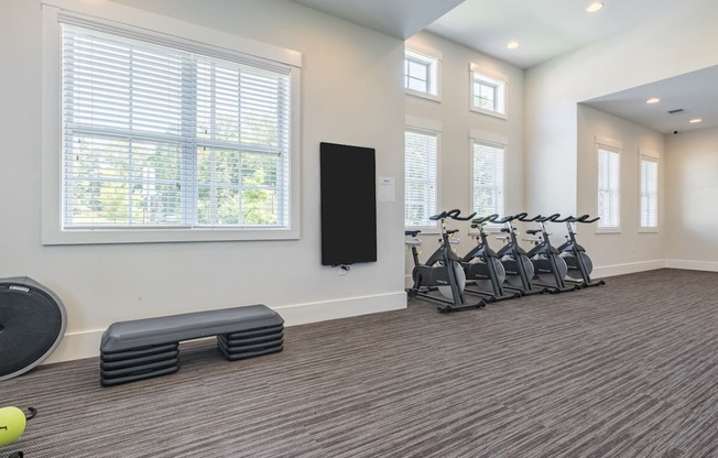 a fitness room with exercise machines and a large window