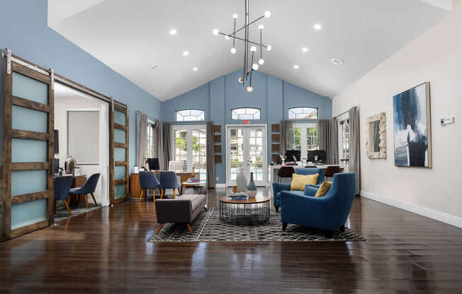 A living room with a blue couch and a wooden floor.