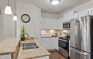 a kitchen with granite counter tops and stainless steel appliances