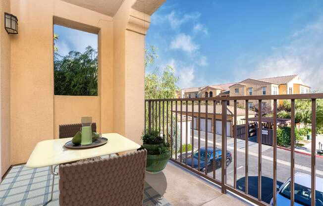 a balcony with a table and chairs and a view of a parking lot